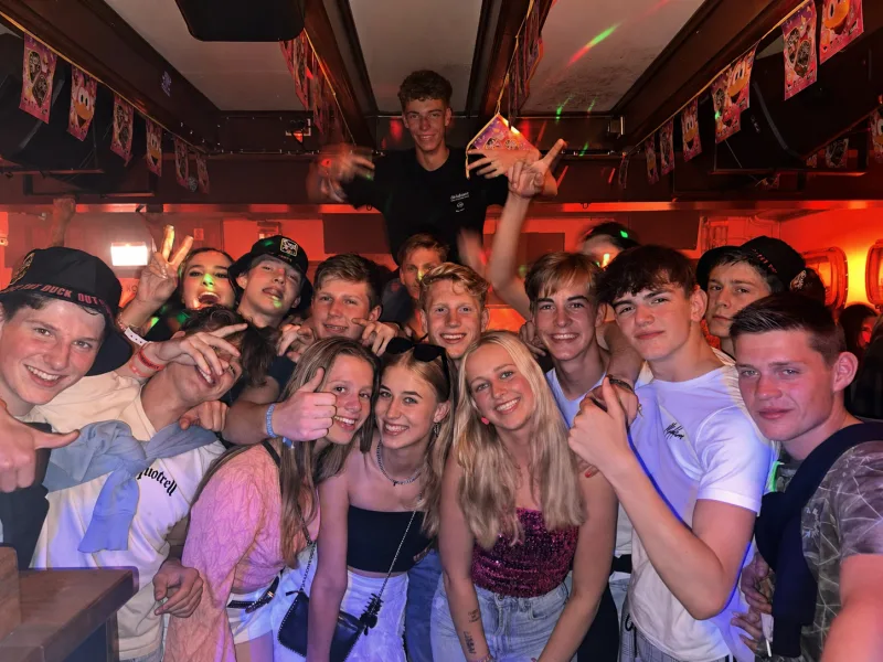 Groep vrienden feest in Schotse Vier onder kleurrijke discolichten