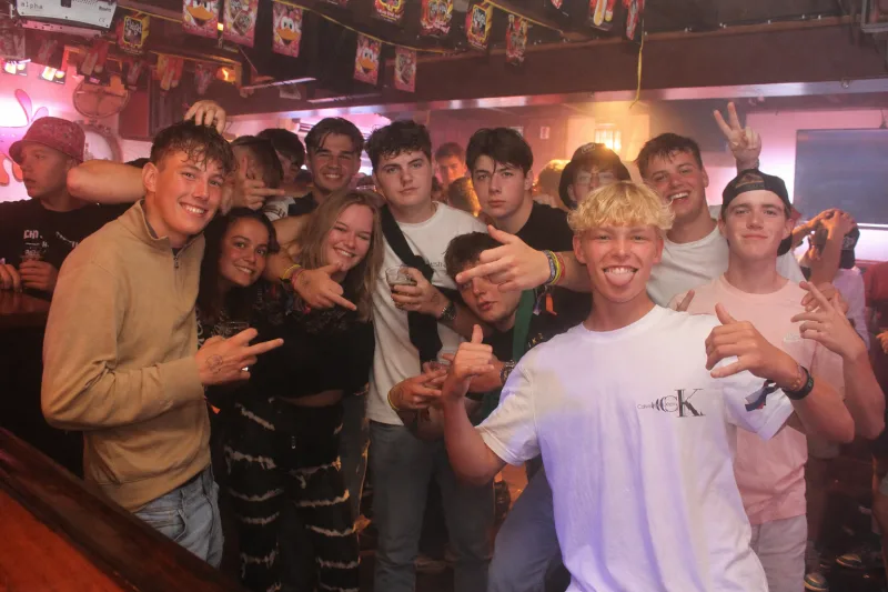Grote groep feestgangers aan de bar bij Schotse Vier
