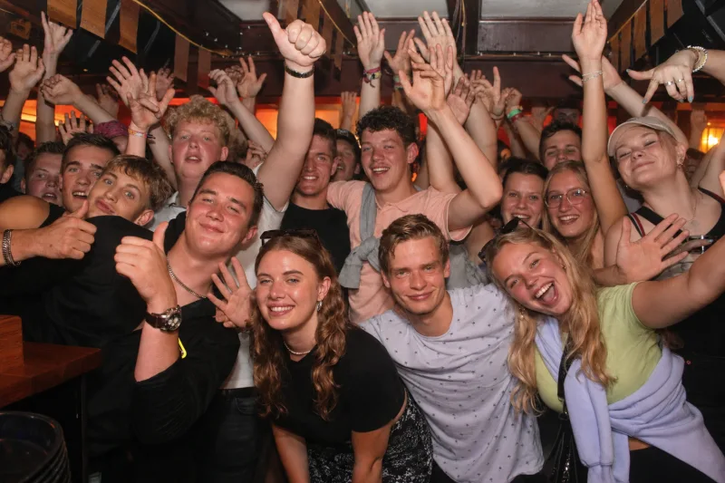 Feestgangers steken hun armen omhoog tijdens een avond bij Schotse Vier